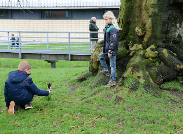 Tijdens de workshop fotografie maakt een Jongen een foto in kikkerperspectief.