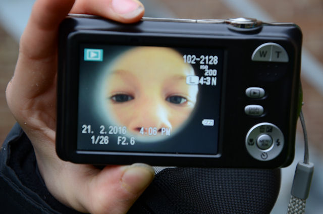 Jongen maakt zelfportret met fotocamera.